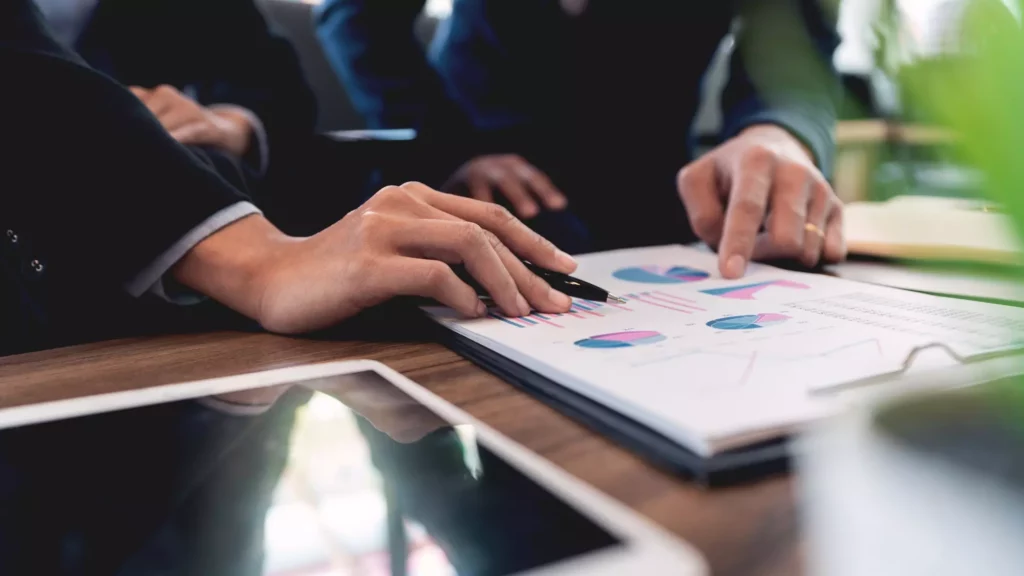 Un director de marketing o un responsable sénior de marketing sentado ante su escritorio, revisando múltiples fuentes de datos en sus pantallas, con aspecto frustrado o absorto en el análisis